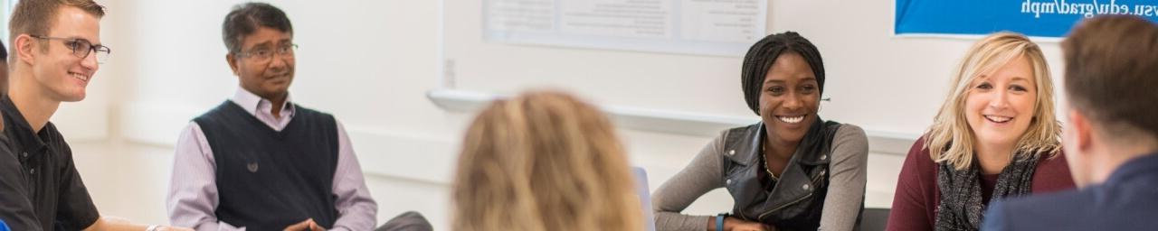 Master of Public Health students engage in a small group discussion, while MPH faculty member Dr. Azizur Molla looks on.